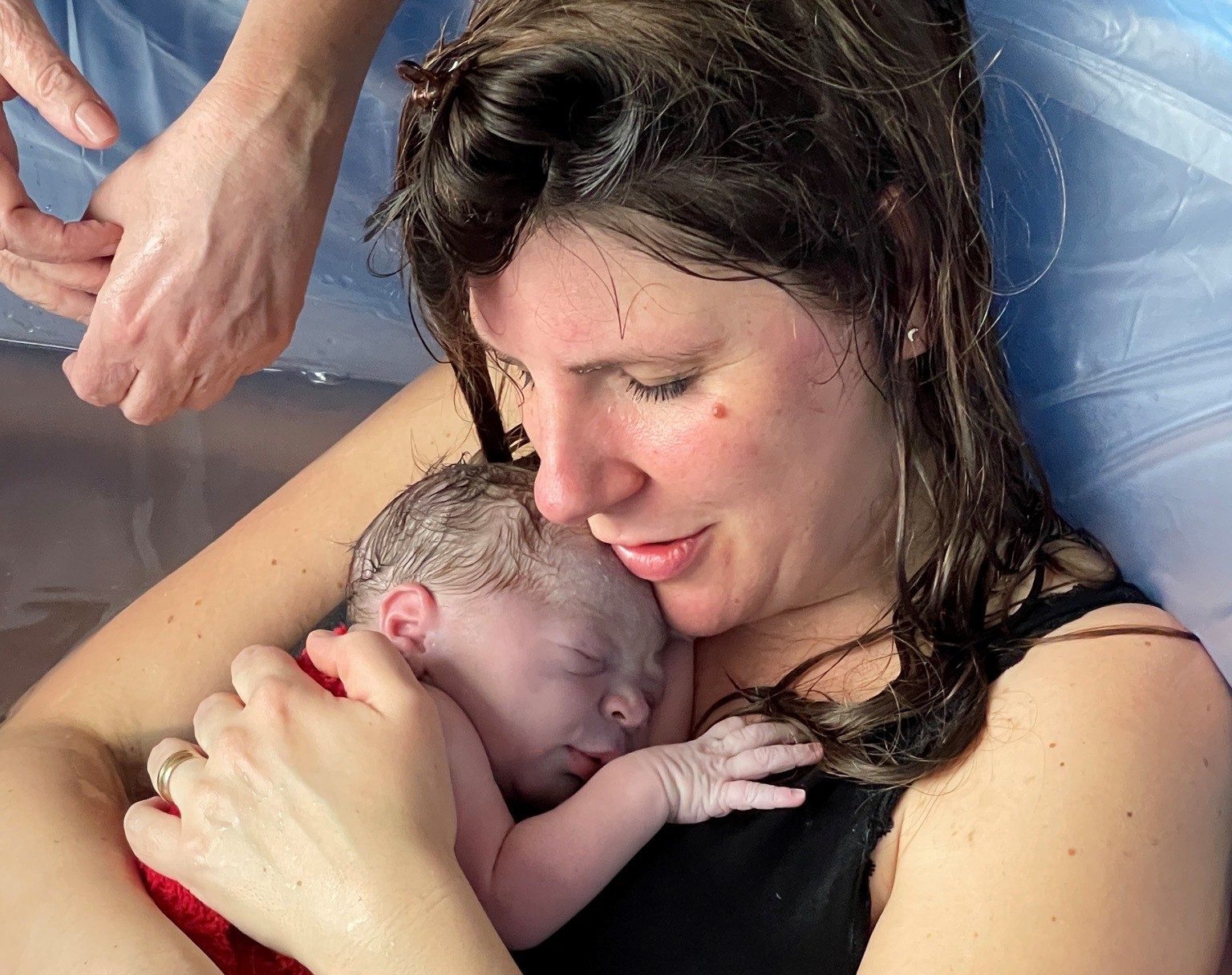 frischgebackene Mama mit Neugeborenem